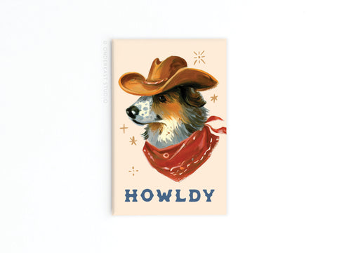 Howldy Cowboy Dog Refrigerator Magnet by Onderkast Studio features a dog in a cowboy hat and red bandana, with “HOWLDY” in bold letters below and decorative stars, bringing playful Western charm to your fridge.
