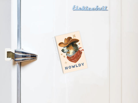 Add a quirky Western touch to your kitchen with Onderkast Studio’s Howldy Cowboy Dog Refrigerator Magnet, featuring a pup in a hat and red bandana and “HOWLDY.” on a white magnet—perfect for any fridge.