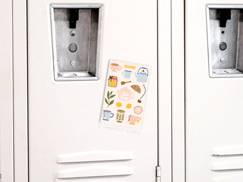 Brighten your kitchen or tea station with the Onderkast Studio Tea Time Refrigerator Magnet, featuring colorful teacups, a teapot, a croissant, and more—perfect for adding charm to any white locker or fridge.