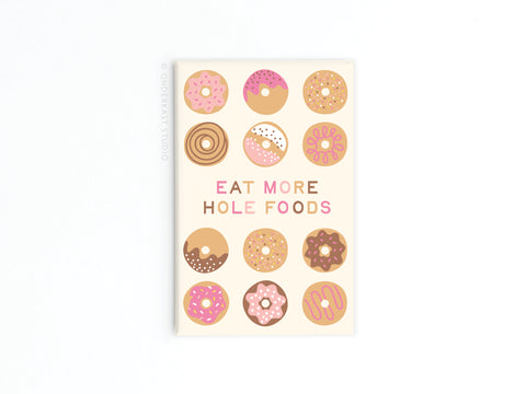 The Hole Foods Donuts Refrigerator Magnet by Onderkast Studio features colorful donut illustrations and the phrase EAT MORE HOLE FOODS on a crisp white background—perfect for kitchen decor or a fun touch to your fridge.