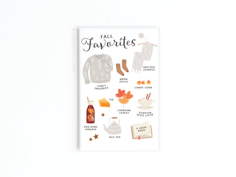 The Fall Favorites Refrigerator Magnet by Onderkast Studio showcases cozy illustrations of a sweater, scarf, socks, autumn treats, and seasonal decor—perfect for celebrating the comforts of fall on your fridge.