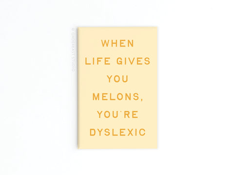 The Life Gives You Melons Refrigerator Magnet by Onderkast Studio is beige with a vibrant design and yellow text: WHEN LIFE GIVES YOU MELONS, YOURE DYSLEXIC, set on a plain white background.