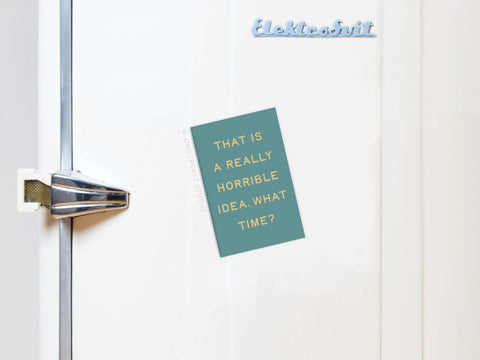 The Onderkast Studio Really Horrible Idea Refrigerator Magnet in teal with yellow text, “THAT IS A REALLY HORRIBLE IDEA. WHAT TIME?”, adds humor to your kitchen décor when displayed on a light blue retro fridge.