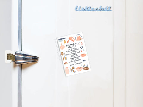 A white vintage fridge with an Elektrobit logo and metal handle displays the Onderkast Studio Birthday Recipe Refrigerator Magnet, featuring kitchen utensil illustrations—a charming way to celebrate lifes moments in your kitchen.