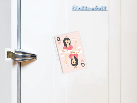 A playful yet regal white fridge displays the Onderkast Studio Yass Queen of Hearts Refrigerator Magnet, holding up a YASS, QUEEN! card with a silver handle and blue Elektrobit logo at the top.
