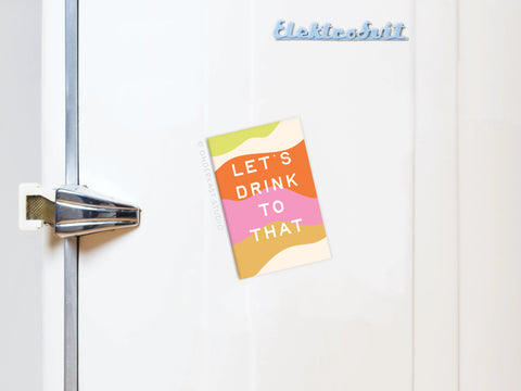 Show off your Onderkast Studio Let’s Drink to That Refrigerator Magnet—featuring vibrant colors, a bold “LETS DRINK TO THAT” design, and stylish retro flair—perfect for upgrading any fridge.