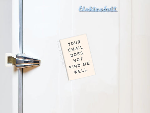 A white fridge with a silver handle displays the Onderkast Studio “Your Email Does Not Find Me Well Refrigerator Magnet,” featuring the phrase in blue text at the top.