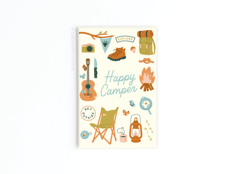 The Happy Camper Refrigerator Magnet by Onderkast Studio features camping-themed illustrations with tents, boots, and a guitar. With cheerful Happy Camper text, its perfect for adding outdoor adventure vibes to your fridge!.