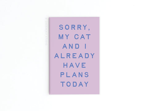 The Onderkast Studio My Cat and I Refrigerator Magnet features pink design, blue text saying Sorry, my cat and I already have plans today, on a white background—perfect for showcasing your feline friendship on your fridge!.