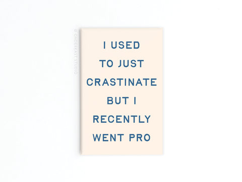 The Crastinater Pro Refrigerator Magnet by Onderkast Studio features a vibrant beige design with blue text: I used to just crastinate but I recently went pro—a perfect way to flaunt your pro-level procrastination skills.