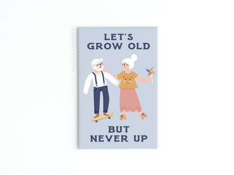 The Let’s Grow Old But Never Up Refrigerator Magnet by Onderkast Studio features a joyful elderly man skateboarding and a smiling woman with a pinwheel, plus the whimsical phrase above—perfect for adding cheer to your fridge!.