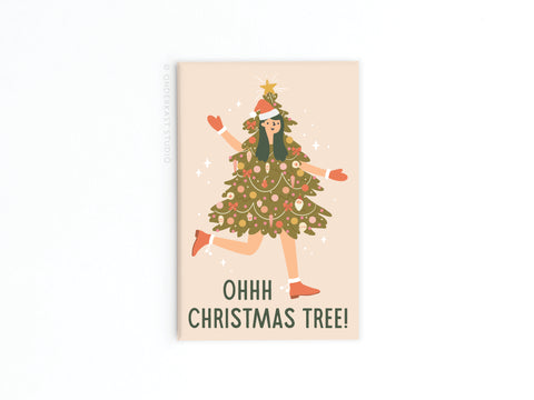The Onderkast Studio Ohh Christmas Tree Girl Refrigerator Magnet features a vibrant illustration of a smiling person dressed as a decorated Christmas tree, with ornaments and a star, standing on one leg. Text below reads OHHH CHRISTMAS TREE!.