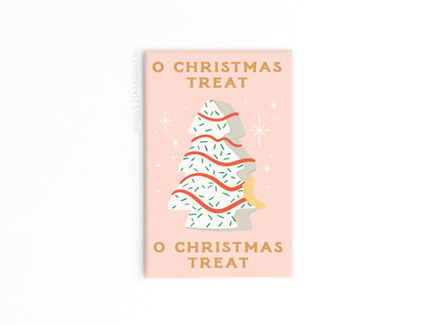 The O Christmas Treat Refrigerator Magnet by Onderkast Studio features a pastel pink card with a white Christmas tree cookie, red and green icing, and an orange cat, plus vibrant colors and “O CHRISTMAS TREAT” text for festive cheer.