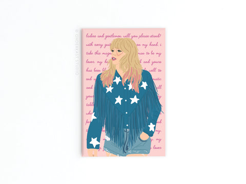 The TS Lover Refrigerator Magnet by Onderkast Studio features an illustrated blonde woman in a blue star jacket and denim skirt on a pink background—an ideal gift for any Swiftie or fan of Taylor lyrics.