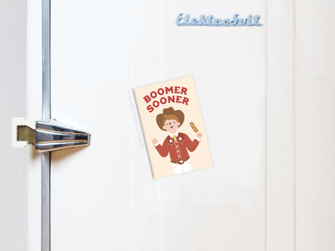 The Boomer Sooner Refrigerator Magnet by Onderkast Studio features a cartoon cowboy and corndog postcard—an ideal accent for Sooners fans fridges.