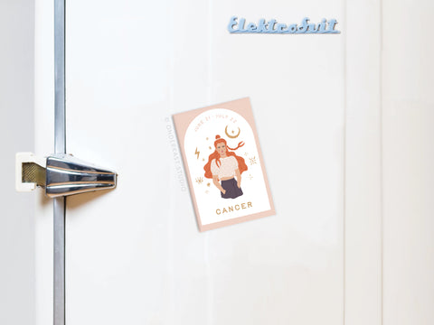 The Onderkast Studio Cancer Zodiac Refrigerator Magnet features an illustrated person, astrological symbols, and dates. Displayed on a white fridge with a chrome handle and Elektrobit label, it’s a perfect decorative zodiac magnet.