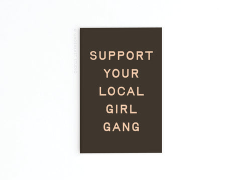 The Support Your Local Girl Gang Magnet by Onderkast Studio is a bold black rectangle featuring the phrase in uppercase light beige letters, centered on white—a striking tribute to female solidarity.