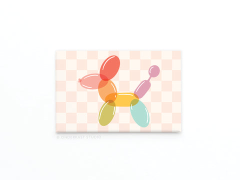 The Balloon Animal Refrigerator Magnet by Onderkast Studio features a pastel checkerboard background and a colorful balloon dog, perfect for adding a whimsical touch to any fridge or magnetic surface.
