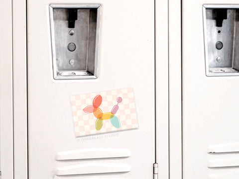 The Balloon Animal Refrigerator Magnet by Onderkast Studio features soft pastel colors and a light checkered background, resembling a playful balloon dog. Perfect for brightening up any magnetic space, this magnet adds charm to your decor.