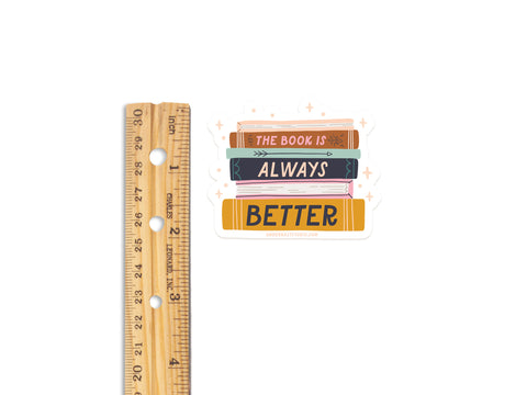 The Book Is Always Better Sticker by Onderkast Studio: a 2.5-inch tall vinyl sticker featuring a stack of books with The Book Is Always Better. Printed in the USA.