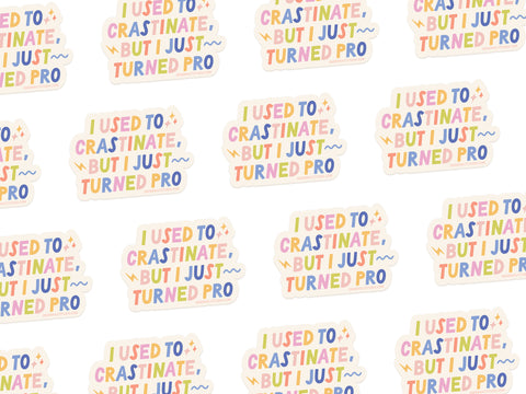 The Crastinator Pro Sticker from Onderkast Studio features colorful text saying I used to procrastinate, but I just turned pro on a white background with an eye-catching design and a white outline.