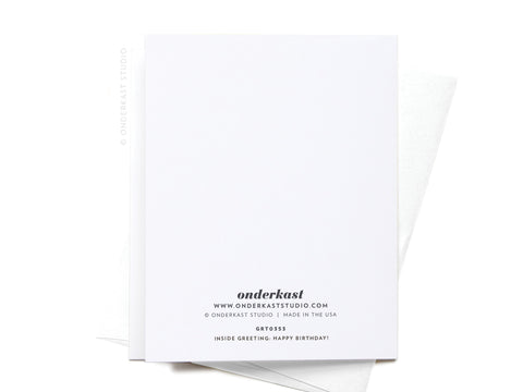 The back of the Old As Balls Greeting Card by Onderkast Studio features the brand name and contact info at the bottom. A white envelope is partially visible beneath the premium card.