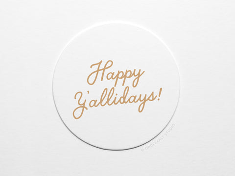 The Happy Y’allidays Coaster Set by Onderkast Studio features white circular coasters with “Happy Yallidays!” in light brown cursive, offering handmade quality and classic design inspired by letterpress.