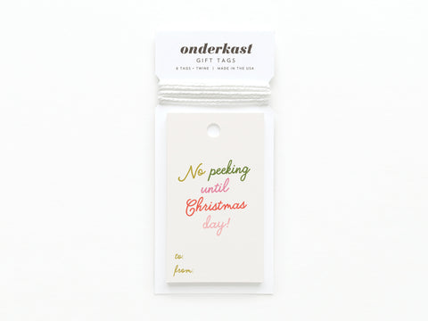 The No Peeking Until Christmas Day Gift Tag by Onderkast Studio is made from premium card stock, features vibrant print, and labeled spaces for to: and from:. Its attached with white twine.