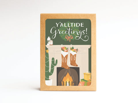The Yalltide Greetings! Folded Greeting Note Set of 10 by Onderkast Studio features a festive fireplace with cowboy boots, flowers, and a decorated cactus on green, printed in the USA on premium card stock.