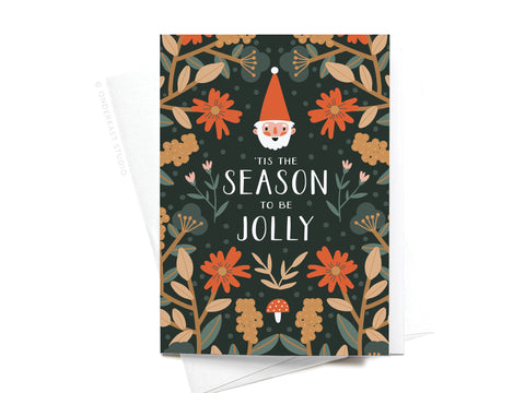Onderkast Studio’s ’Tis the Season to Be Jolly Folded Greeting Note Set of 10 features a Santa face with red flowers, beige foliage, and mushrooms on dark green. Printed in the USA on premium card stock.