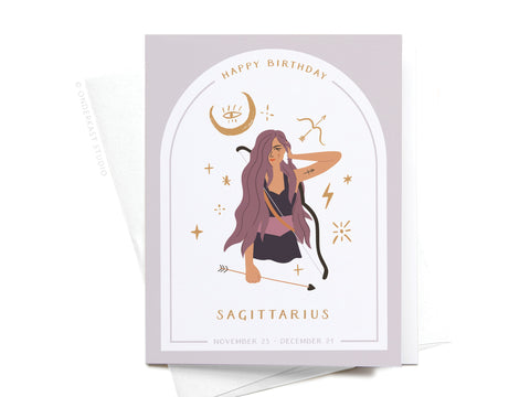 Onderkast Studio’s Happy Birthday Sagittarius Zodiac Greeting Card features an illustrated woman with long purple hair holding a bow, surrounded by stars. Text: “Happy Birthday” and “Sagittarius, November 23 - December 21.” Printed in the USA.