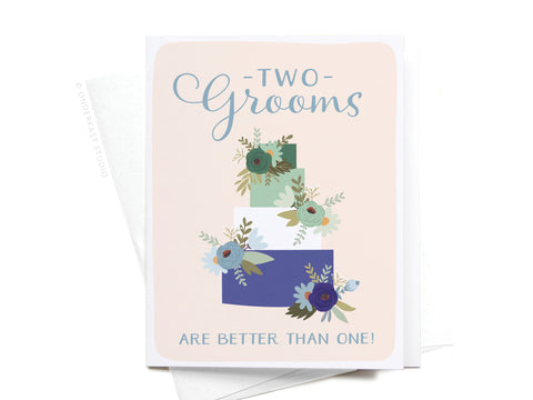 The Onderkast Studio Two Grooms Are Better Than One Greeting Card features a four-tiered floral wedding cake and the phrase Two Grooms are better than one! in blue and teal script on a pale background.
