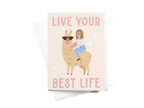 The Live Your Best Life Llama Sticker Greeting Card by Onderkast Studio features a smiling woman riding a sunglasses-wearing llama, surrounded by sparkles, with LIVE YOUR BEST LIFE text on white card stock.