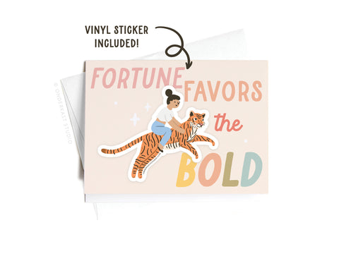 The Fortune Favors the Bold Tiger Sticker Greeting Card by Onderkast Studio features a woman riding a tiger with the phrase “Fortune favors the bold” on thick white card stock and includes a matching vinyl sticker.