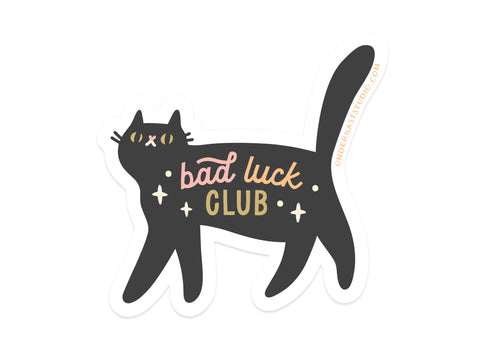 The Bad Luck Club Sticker by Onderkast Studio features a black cat with yellow eyes and “bad luck CLUB” in pink, yellow, and white, plus sparkles—perfect for adding some magical flair to your collection!.