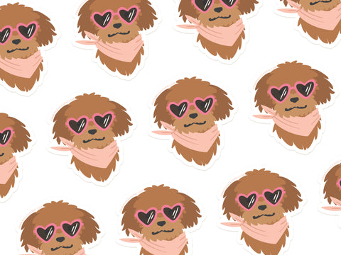 The Dog w/ Heart Sunglasses Sticker by Onderkast Studio features a brown fluffy dog in pink heart glasses and a bandana on white, perfect for making cute, water-resistant vinyl stickers.