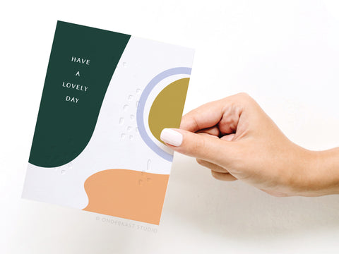 a hand holding a card that says have a lovely day