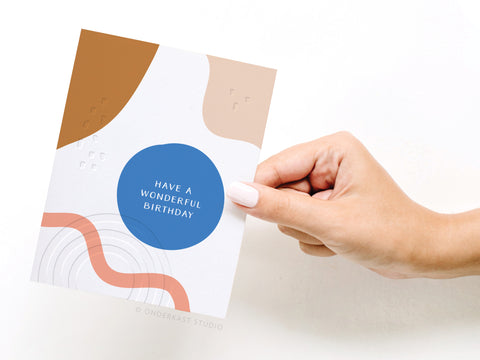 a hand holding a birthday card that says have a wonderful birthday