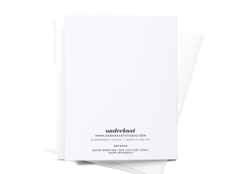 A white OMG Youre Finally [21] greeting card from Onderkast Studio sits atop a matching envelope. The back has branding and reads “onderkast.” Inside greeting: Shit just got legal. Happy birthday!.