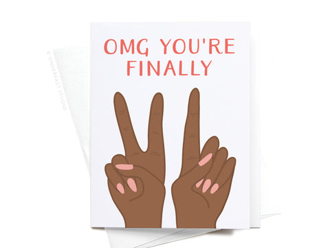 The OMG Youre Finally [21] Greeting Card by Onderkast Studio features two brown-skinned hands with pink nails holding up two fingers each, pink text reading OMG YOURE FINALLY, and comes with a white envelope.